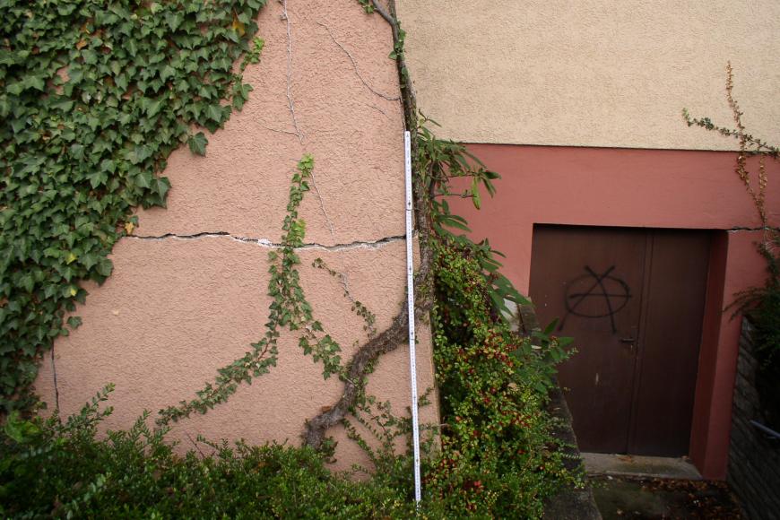 Blick auf die Außenwand eines Gebäudes mit einem waagrecht verlaufenden Riss im Mauerwerk.