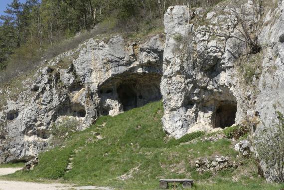 Hagentorhöhle bei Veringenstadt Seitlicher Blick auf eine an einem nach links geneigten Hang sich erhebende Höhle. Die Höhle besteht aus weißlichem, stark durchlöchertem Gestein. Eingänge finden sich rechts vorne sowie links hinten.