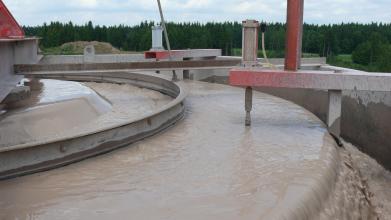Ausschnitt einer Aufbereitungsanlage für Sand. In metallenen runden Becken wird das Bodenmaterial durch Wasser gereinigt.