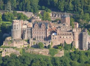 Gesamtansicht des Heidelberger Schlosses mit Maueranlagen und eingerüsteten Türmen.