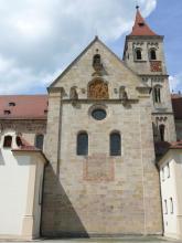 Das Bild zeigt das Querschiff einer Kirche in Ellwangen, dessen Mauerwerk aus gelblich braunem Stubensandstein besteht.