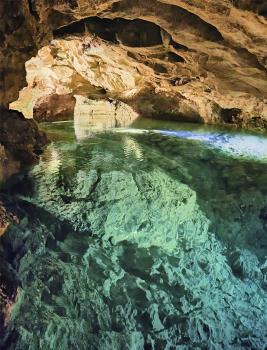 Friedrichshöhle bei Hayingen (Wimsener Höhle); Foto: Reinhold Schumann Blick in das Innere einer Höhle. Der blaugrün schimmernde Boden wird von einem See bedeckt. Die zerklüftete Decke ist gewölbt und hellbraun gefärbt, wo Licht sie erhellt.
