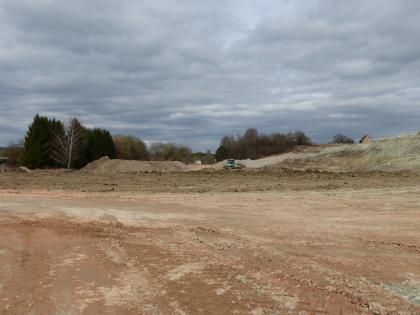 Ziegeleigrube in der Unteren Süßwassermolasse südwestlich von Mengen – teilweise verfüllter Bereich Das Bild zeigt eine teilweise verfüllte Ziegeleigrube. Rechts im Hintergrund ist noch eine niedrige Abbauwand zu erkennen. Links davon ist eine Planierraupe im Einsatz.