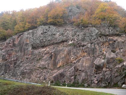 Felsböschung an der Straße Witznau-Berau Blick auf eine rötlich graue, massige Felsböschung, die entlang einer Straße verläuft. Der obere Teil der Böschung ist bewaldet.