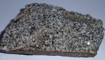 St. Blasien-Granit Nahaufnahme eines Handstückes von Sankt Blasien-Granit. Das Stück ist länglich rechteckig und grau mit dunkleren Einsprenglingen.