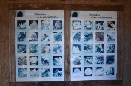 Schautafel beim Aussichtspunkt auf dem Bildsteinfelsen Blick auf eine zweiteilige Schautafel aus Holz. Auf der Tafel sind zahlreiche Fotos angebracht, die Mineralien aus der Grube Gottesehre zeigen.