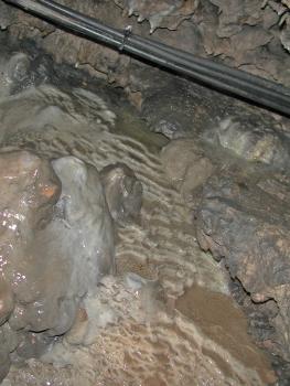 Höhlenbach mit Sinterbildungen in der Tschamberhöhle bei Rheinfelden Teilansicht eines schmalen Höhlenbachs. Unter dem flachen Wasser befinden sich Sinterbildungen, die Schaumkronen ähneln.