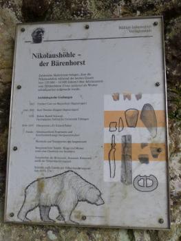 Schautafel an der Nikolaushöhle bei Veringenstadt Blick auf eine Schautafel mit Texten und Bildern zur Nikolaushöhle bei Veringenstadt. Die Höhle wurde während der letzten Eiszeit häufig von Bären als Winterschlafquartier besucht. Auch zahlreiche Funde von Werkzeugen und Tonscherben wurden gemacht.