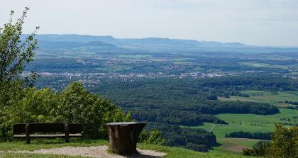 Blick über das Filstal bei Göppingen und das Albvorland zum Albtrauf – Die vorgelagerte Bergkuppe ist der vulkanisch entstandene Turmberg und Aichelberg; rechts dahinter der Breitenstein, rechts daneben der Teckberg und hinten die Reutlinger Alb Blick von einem hochgelegenen Aussichtspunkt auf eine hügelige Landschaft mit quer verlaufendem, besiedeltem Taleinschnitt. Nach rechts hin breiten sich Waldflächen aus. Links sowie im Hintergrund erheben sich abgestufte Höhenzüge.