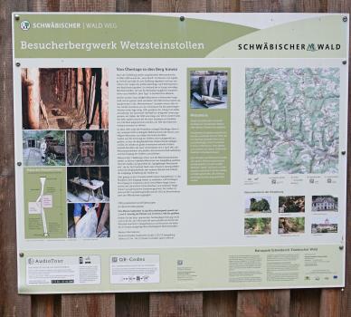 Wetzsteinstollen Spiegelberg – Infotafel zum Besucherbergwerk Blick auf eine große Schautafel mit Texten und Bildern zum Besucherbergwerk Wetzsteinstollen Spiegelberg. Auf der Tafel ist auch eine Skizze zum Bergwerk sowie Näheres zu Wetzsteinen zu finden.