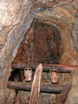 Blindstollen mit Geleucht in der Grube Segen Gottes bei Haslach im Kinzigtal Blick auf das Stollenende in einem alten Bergwerk. Im Vordergrund sind quer verkeilte Holzstützen mit daran befestigten alten Laternen zu sehen.
