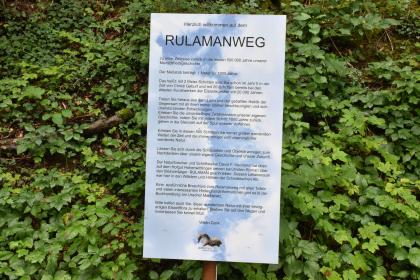 Informationstafel am Beginn des Rulamanwegs Blick auf eine hohe beschriftete Tafel, die Besucher des Rulamanweges freundlich begrüßt.