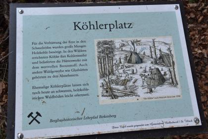 Infotafel an einem ehem. Köhlerplatz am bergbauhistorischen Lehrpfad Birkenberg bei Bollschweil-St. Ulrich Blick auf eine Schautafel, aufgestallt am bergbauhistorischen Lehrpfad Birkenberg bei Bollschweil-St. Ulrich. Die Tafel erzählt von ehemaligen Köhlerplätzen, illustriert mit einem alten Holzchnitt oder Kupferstich von Köhlern bei ihrer Arbeit.