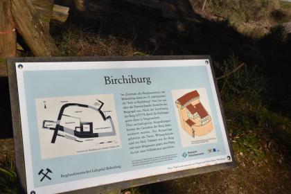 Informationstafel zur ehem. Birchiburg am bergbauhistorischen Lehrpfad Birkenberg bei Bollschweil-St. Ulrich Leicht seitlicher Blick auf eine farbige Schautafel, angebracht am bergbauhistorischen Lehrpfad Birkenberg bei Bollschweil-St. Ulrich. Die Tafel gibt Auskunft über die einst hier erbaute Birchiburg, ergänzt durch Grundriss und Rekonstruktionszeichnung.