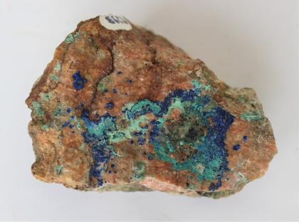 Azurit (blau) und Malachit (grün) aus der Schlächtenhaus-Kupfergrube bei Endenburg Großaufnahme eines bräunlichen Gesteinsstückes mit blauen und grünen Einlagerungen.