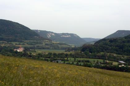 Blick nach Osten in das Filstal zwischen Deggingen und Bad Überkingen Über eine abschüssige Wiese blickt man auf ein eng wirkendes Tal mit Grün- und Nutzflächen (Fussballfeld). Steile bewaldete Hänge rechts und links geben den Blick zur Mitte frei, wo sich weitere, mit Felsen bestückte Anhöhen zeigen.