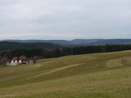 Blick vom Witthoh nach Nordnordwesten über das Donautal bei Tuttlingen und auf die angrenzenden bewaldeten Hochflächen Das Bild zeigt leicht wellig verlaufende, nach links abfallende, kiesreiche Ackerflächen. Im Hintergrund sind bewaldete Höhenzüge erkennbar.