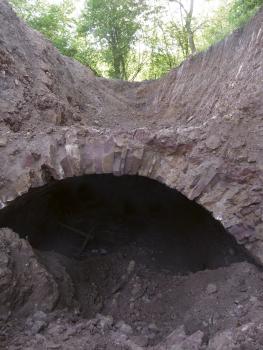 Durch Baggerarbeiten 2012 freigelegtes Portal des Oberen Schlierbergstollens Offenbar durch Bauarbeiten freigelegte, tunnelartige Öffnung eines Stollens. Das Gestein des Tunnelbogens ist schwach rötlich bis grau.