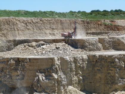 Steinbruch im Oberen Muschelkalk bei Zimmern ob Rottweil Blick auf mehrere Stufen eines Steinbruchs. Das gebankte Gestein ist bräunlich grau bis grau.