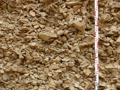 „Albschutt“ mit gleichmäßiger Korngrößenverteilung Nahaufnahme von kleinen bis größeren, rötlich braunen Steinen. Die Steine sind über mehrere Zentimeter aufgetürmt und bilden so eine Wand.