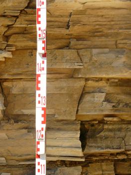 Regelmäßig geschichtete Nusplinger Plattenkalke Nahaufnahme von rötlich braunem Gestein, das in dünnen Lagen gleichmäßig aufeinandergeschichtet ist.