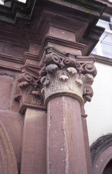 Klosterkirche zu St. Peter im Schwarzwald mit Heimbacher Sandstein Aufwärts gerichteter Blick auf eine Säule sowie Kapitelle aus rötlich grauem Gestein an einer Kirchenfassade.