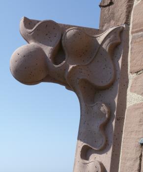 Neugefertigte Krabbe aus hellrotem Lahrer Sandstein am Freiburger Münster Blick auf eine Verzierung aus rötlich grauem Stein; angebracht an der Außenwand eines Gebäudes.