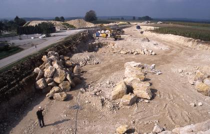 Im Sommer 2010 begonnener Steinbruch der Fa. Traco, Bad Langensalza Blick über ein flaches Steinbruchgelände mit Blockhaufen in der Mitte und links sowie Zufahrtsstraßen und Abraumhalden links im Hintergrund.