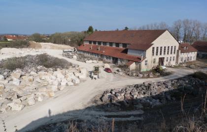 Werkhalle des Steinbruchs Gauingen Blick auf die ältere Werkhalle eines Steinbruches. Links der Halle und davor liegen Steinblöcke in unterschiedlichen Farben und Größen.