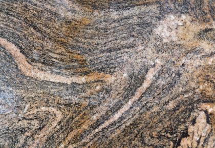 Anatexit, Dreisamschotter Freiburg i. Br. Nahaufnahme einer von Streifen und Schlieren durchsetzten Gesteinsoberfläche. Die Farbskala des Gesteins reicht von blaugrau über braun bis rosa.