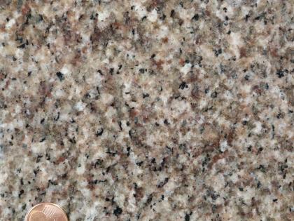 Heidelberg-Granit: Steinbruch Weinheim-Steinklingen, Wildeleutstein Nahaufnahme einer Gesteinsoberfläche, die in Farbe und Anordnung an Speckwürfel erinnert. Links unten ist noch ein Teil einer Cent-Münze sichtbar.