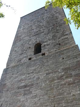 Die Yburg wurde vollständig aus Leisberg-Porphyr erbaut Teilansicht eines hohen Burgturms aus rötlich grauen Mauersteinen. In der Bildmitte ist eine Fensteröffnung im Turm eingelassen.
