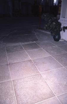 Boden aus Steinweiler Platten in der Abteikirche von Neresheim Blick auf rötlich graue Bodenplatten in einem Kirchenraum, im Vordergrund durch Blitzlicht erhellt.