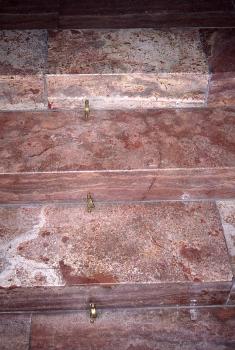 Detail der Altartreppe, Kirche Riedöschingen Teilansicht von steinernen Stufen in einer Kirche. Die Stufen sind rötlich grau bis hellgrau gefärbt und weisen Schlieren und Flecken auf.