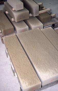 Frisch bearbeitete Werkstücke aus Niederhofener Sandstein Blick auf frisch bearbeitete Werkstücke aus hellbraunem, an manchen Ecken weißlichem Gestein; unterschiedlich lang und breit, auf Paletten und Querhölzern ausgelegt.