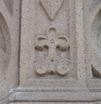Ornament an der Kirche in Waldenbuch aus Stubensandstein aus dem Schönbuch Teilansicht einer Kirchenfassade aus hellgrauem, fleckigem Stein mit herausgearbeitetem Ornament in Form einer Kreuzblume.