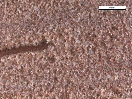 Mikroskopaufnahme des Bausandsteins aus dem Steinbruch Loßburg (Beilstein, RG 7616-375). Mikroskopaufnahme eines hellroten Sandsteins mit einer Mittelsand-Grobsand-Wechsellagerung und einer Tonschmitze.