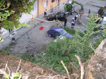 Blick von oben auf den Sturzraum Blick von oben auf einen an einen Felshang angrenzenden Hof. Auf dem Hof befinden sich PKWs und ein paar Menschen.