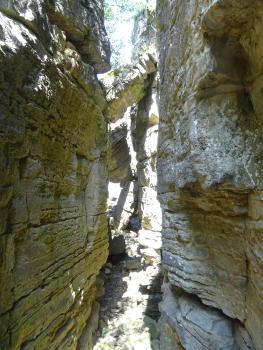 Abgestürzte Felspartien in den Hessigheimer Felsengärten Das Foto zeigt zwei links und rechts steil aufragende, durch einen schmalen Zwischenraum getrennte Felswände. In diesem Zwischenraum sind mehrere Felspartien zu sehen, die abgestürzt und sich an der gegenüberliegenden Wand verkeilt haben.