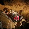 Blick von oben in den Schacht einer Höhle. Stein- und Metalltreppen führen Besucher von unteren Sohlen nach oben.