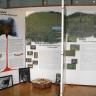 Blick auf mehrere bebilderte Schautafeln, aufgestellt im Naturzentrum Kaiserstuhl. Neben der vulkanischen Geschichte gibt es auch die Themen „Halbtrockenrasen“ und „Reben“.