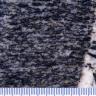 Großaufnahme einer links grau und schwarz gestreiften Gesteinsoberfläche. Rechts ist ein kleiner Teil weiß gefärbt, mit stiftartigen schwarzen Einschlüssen. Am unteren Bildrand verläuft eine Millimeterskala.