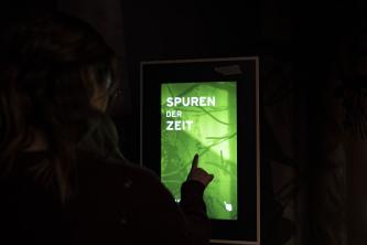 Blick ins Innere des Museums im Nationalparkzentrum Schwarzwald. Mit einem Fingertip kann man einen Bildschirm aktivieren und sich Wissenswertes vorführen lassen, im Bild als Beispiel "Spuren der Zeit".