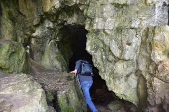 Die Sibyllenhöhle auf dem Teckberg unterhalb des Aussichtsturms Blick auf den Eingangsbereich einer Höhle mit grünlich verfärbten Felswänden. Ein schmaler, rechts gezackter Spalt führt ins Innere der Höhle.