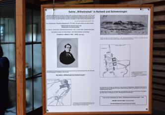 Blick auf ein Plakat im Salinenmuseum Wilhelmshall mit Informationen zum ehemaligen Leiter der Saline, Friedrich von Alberti, sowie Lageplänen und einer Ansicht der damaligen Gebäude in Schwenningen.