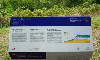 Dreisprachige, mehrfarbige Informationstafel aus Metall zum Zeugenberg Hohenstaufen. Rechts ist eine Schnittzeichnung zum geologischen Aufbau des Berges zu sehen, links oben eine Wegskizze.