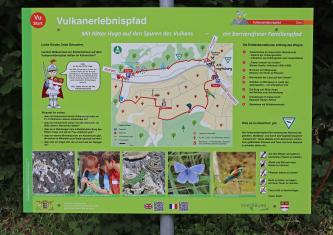 Blick auf eine farbige Schautafel am Start des Vulkanerlebnispfads bei Vogtsburg. Neben Fotos von Vulkangestein und der hier zu findenden Tierwelt wird auch der Verlauf des Lehrpfads mit verschiedenen Stationen gezeigt.