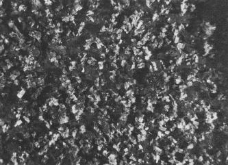 Vergrößertes Bild von Gipskristallen. Die Spitzen der Kristalle schimmern hellgrau, tiefer liegende Bereiche sind dunkelgrau und schwarz.