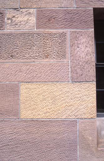 Teilansicht  von rötlichem und gelblichem Mauerwerk mit unterschiedlicher Struktur der Oberflächen: Schraffuren nach links und rechts, Kreuzschraffuren, feine Knoten und anderes.